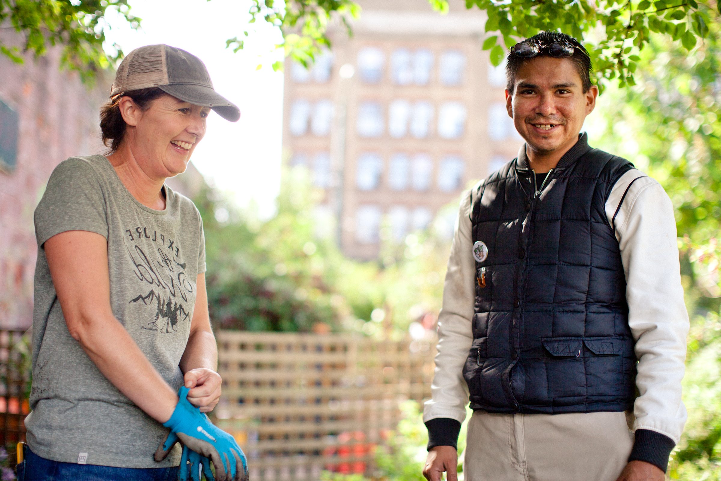 A man and a woman smiling in a community garden