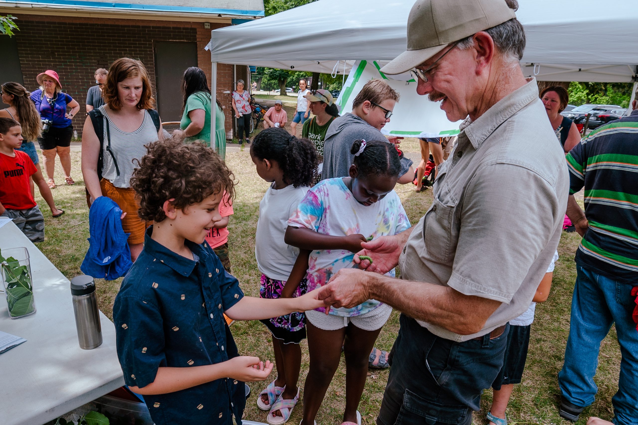 A man showing caterpillars to kids during a workshop