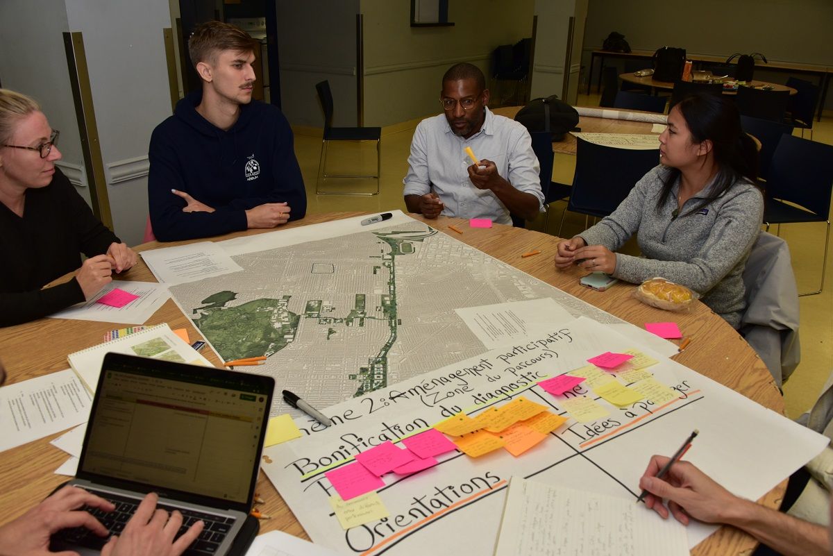 Plusieurs personnes assises et discutant avec une carte du Corridor écologique Darlington sur la table