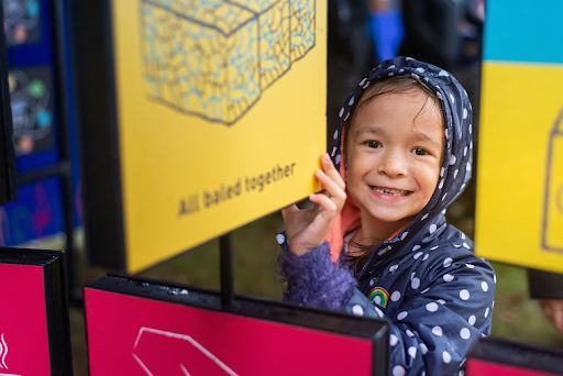 A little girl smiling an playing under the rain