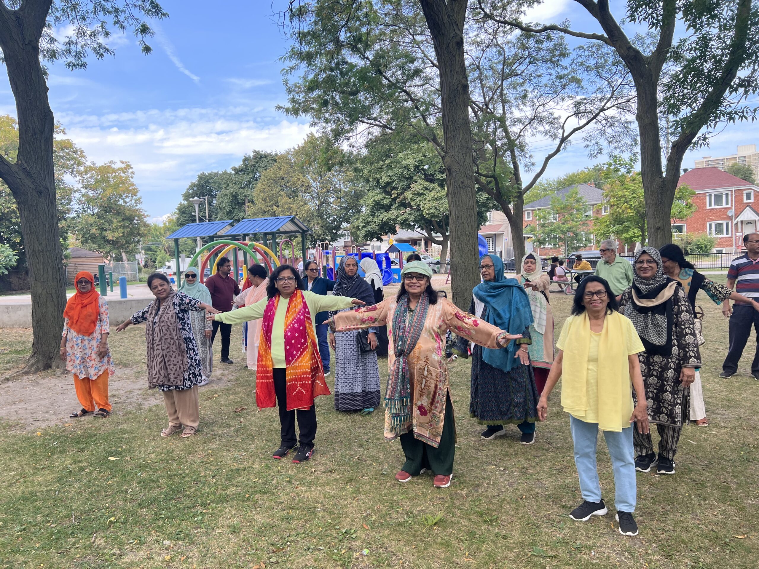 A group of men and women doing yoga in a park